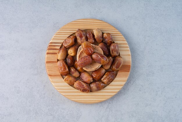 Yellow dry dates in a wooden platter.