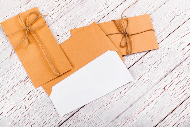 Yellow envelopes twined with rope lie on white wooden table