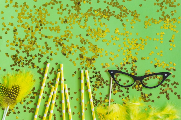 Yellow feathers with golden confetti and black glasses