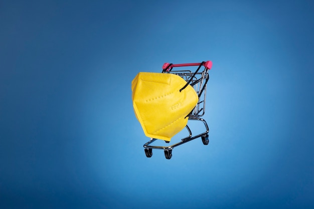 Free photo yellow ffp2 mask and shopping cart