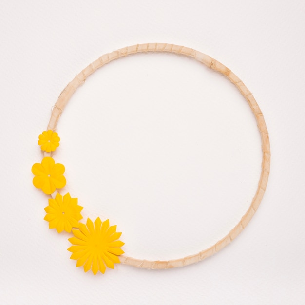 Yellow flowers on the circular frame border on white backdrop