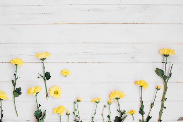 Free photo yellow flowers on wooden table