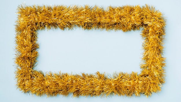 Yellow frame from tinsel on blue table