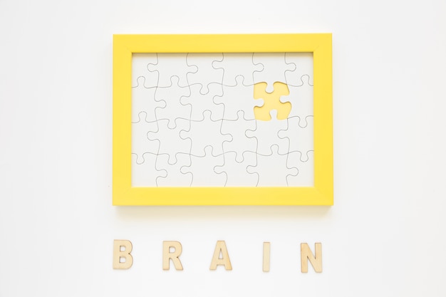 Желтая рамка с отсутствующим головоломкой рядом с мозговым словом