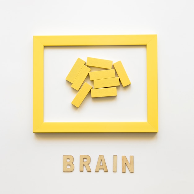 Желтая рамка с деревянными блоками возле слова мозга