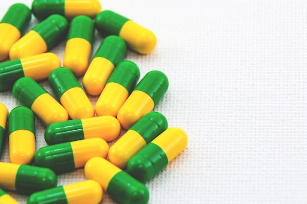 Free photo yellow and green capsules on a white surface