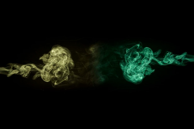 Foto gratuita fumo giallo e verde su sfondo nero