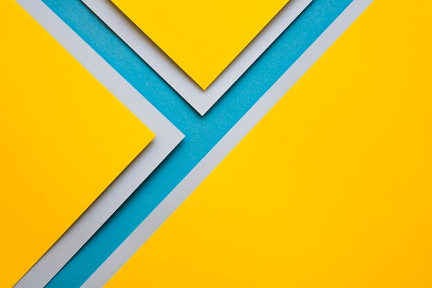 Yellow and grey craftpapers on blue surface