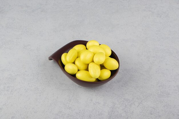 Yellow gums in the bowl on the marble surface