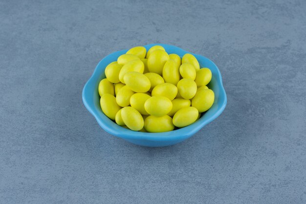 Yellow gums in the bowl, on the marble table. 