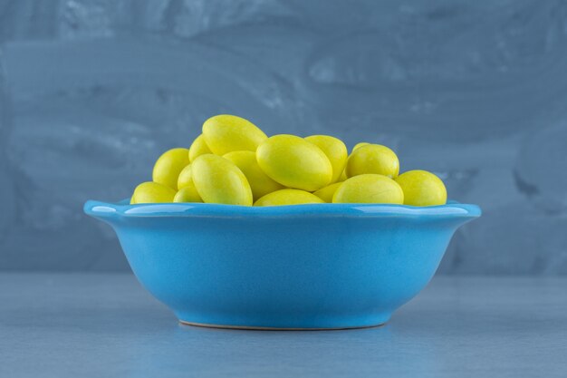 Yellow gums in the bowl, on the marble table. 