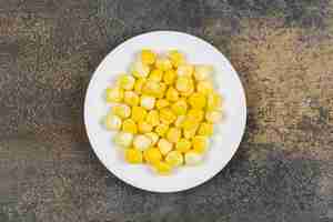 Free photo yellow hard candies on white plate.