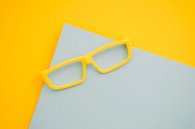 Yellow kids eyeglasses on gray and yellow background