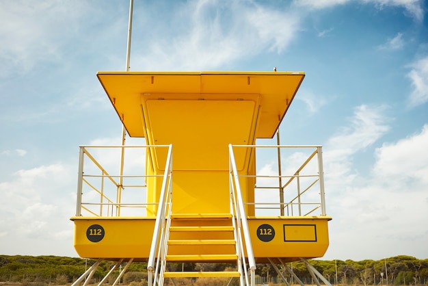 Foto gratuita bagnino giallo post onn spiaggia vuota