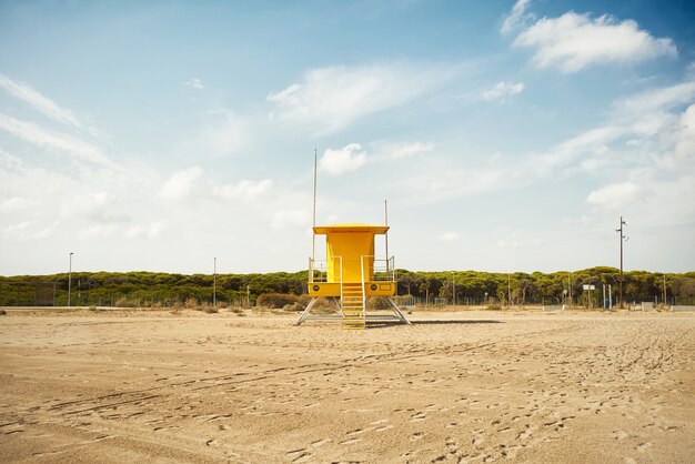 黄色いライフガードポストオン空のビーチ