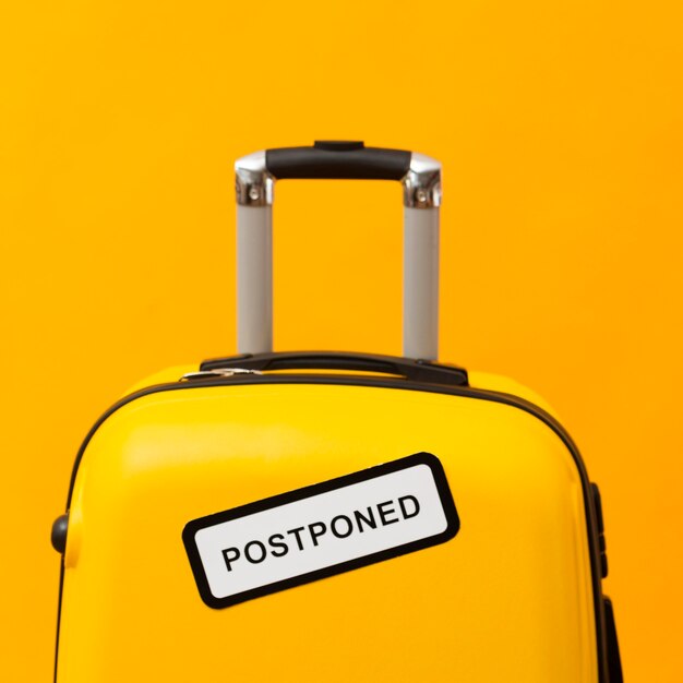 Yellow luggage with postponed sign