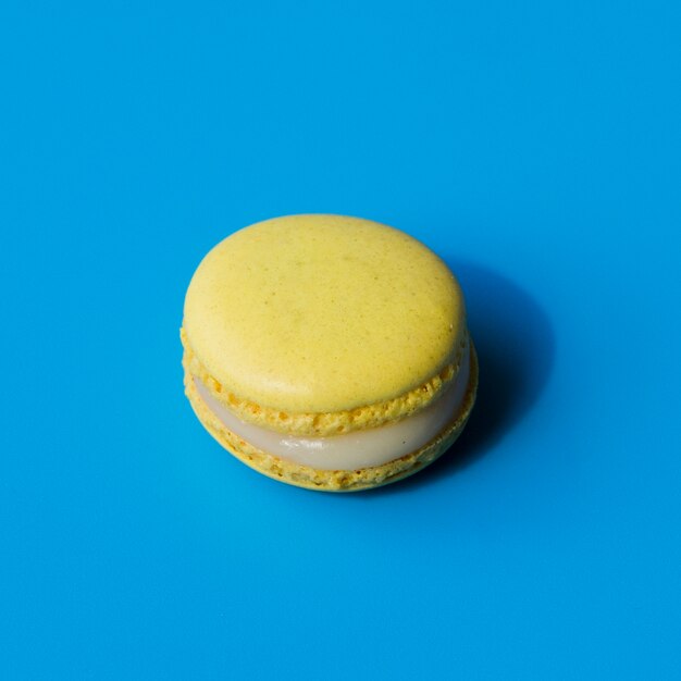 Yellow macaroon on blue background