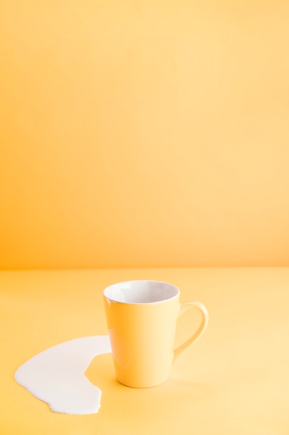 Yellow mug with spilled milk