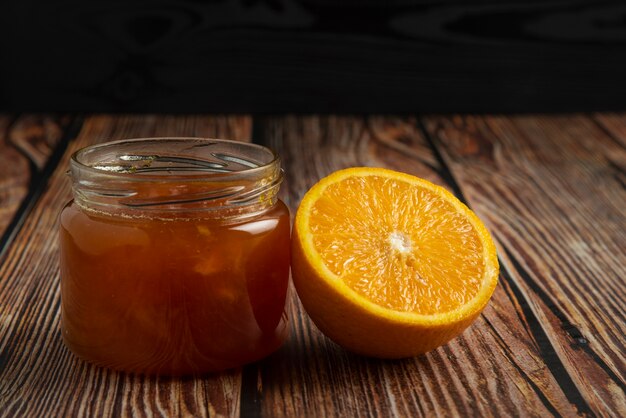 Yellow oranges with a jar of confiture.