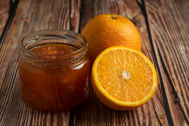 Free photo yellow oranges with a jar of confiture.