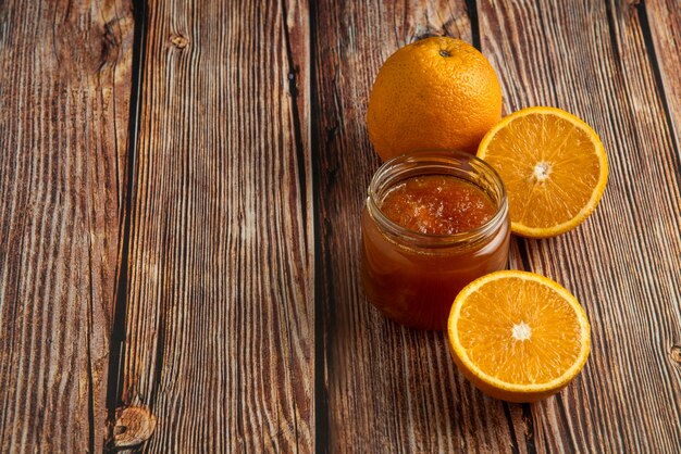 Yellow oranges with a jar of confiture.