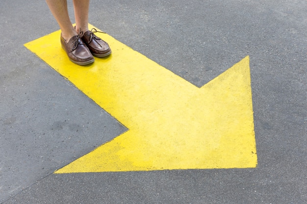 Yellow painted arrow in the streets and legs