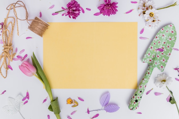 Free photo yellow paper and spade with flower