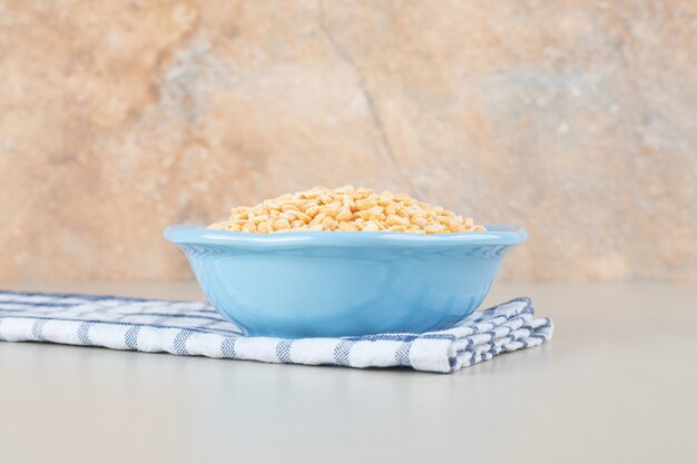 Yellow pea beans in a blue ceramic cup.