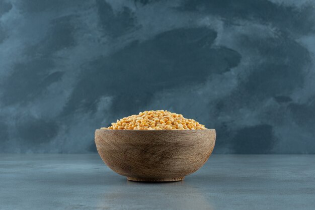 Yellow pea beans in a bowl on blue background. High quality photo