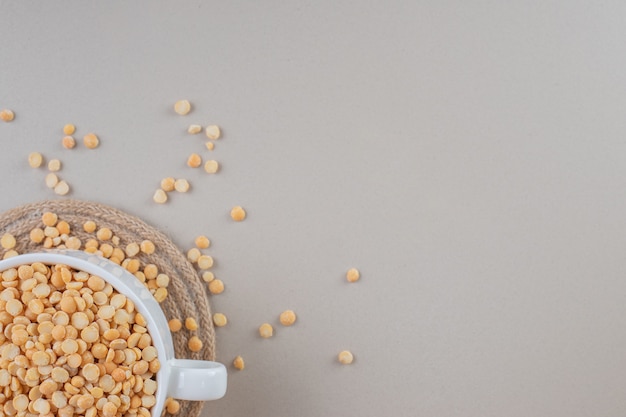 Fagioli di pisello gialli in una ciotola di ceramica su calcestruzzo.