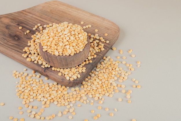 Yellow pea beans on a wooden board on concrete.