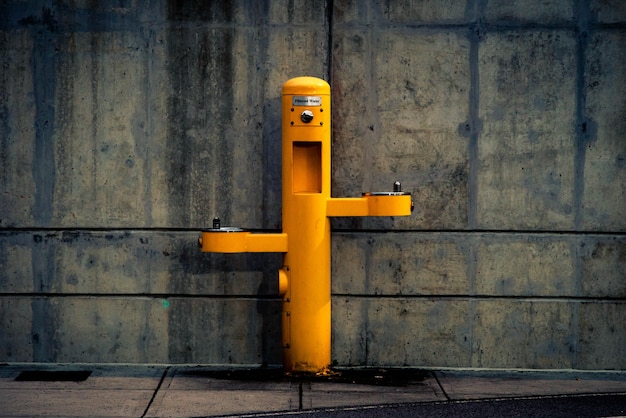 Yellow pedestal outdoor post against the wall