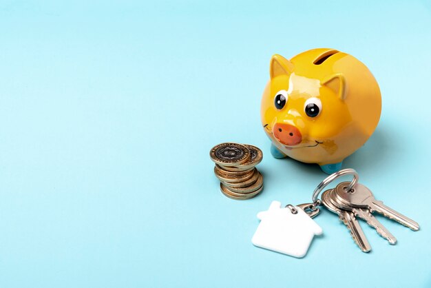 Yellow piggy bank with keys on copy space background