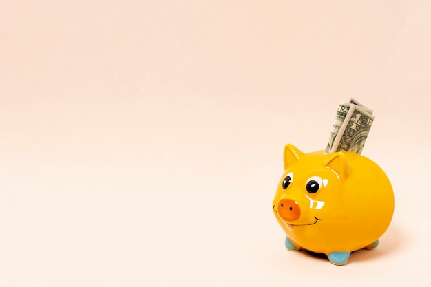 Yellow piggy bank with money and copy space background Premium Photo