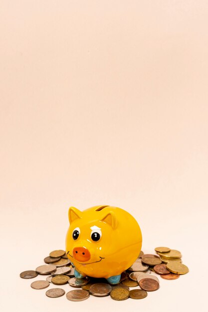 Yellow piggy bank with a stack of coins