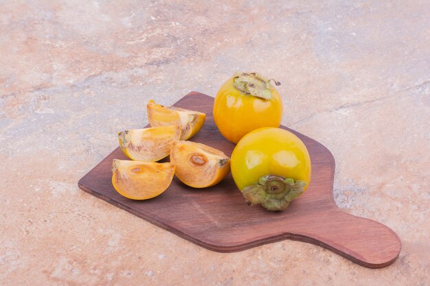 Yellow plum dates isolated on a wooden platter.