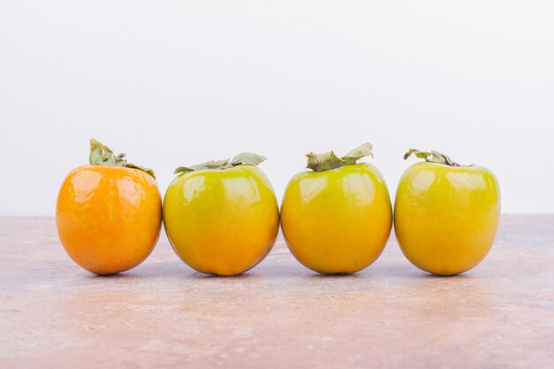 Yellow plum dates on a pink marble surface