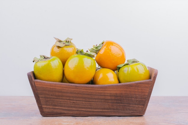 Yellow plum dates in a wooden tray.