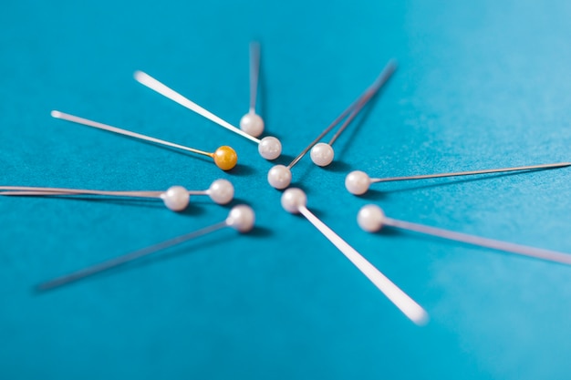 Yellow push pins with white pins on blue background