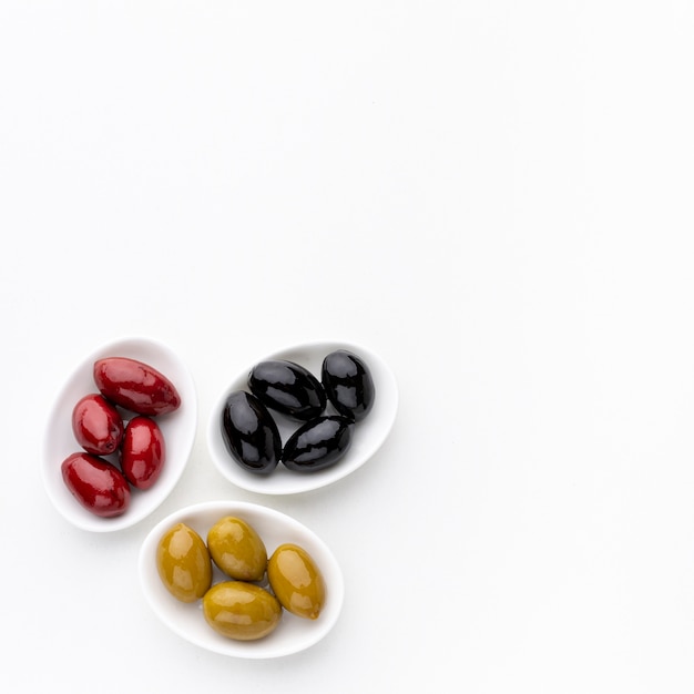 Yellow red black olives on plates