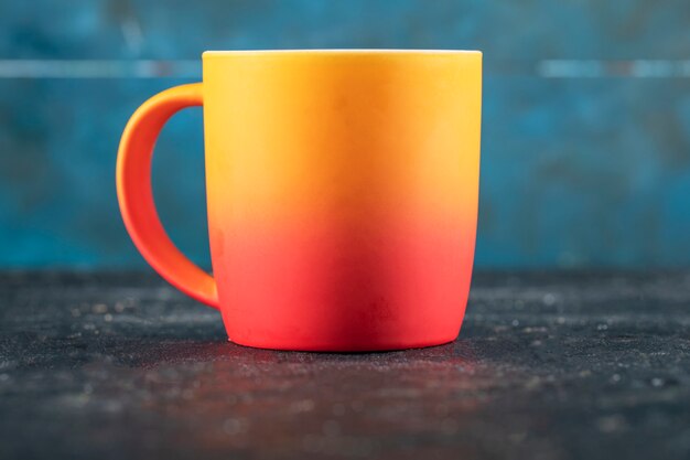 A yellow and red colored mug for drink