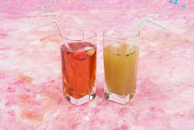 A yellow and red glasses of juice.