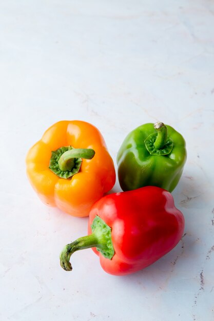 yellow, red and green peppers on white table