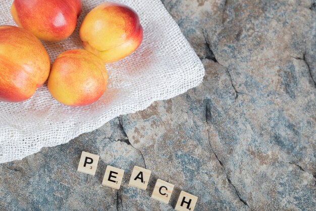 Yellow and red peaches on a piece of white towel. 