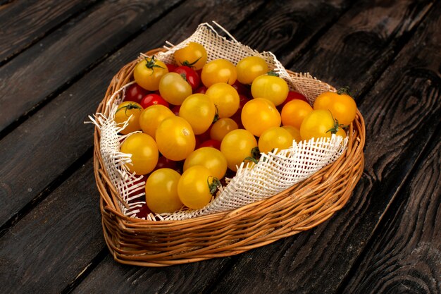 Yellow red tomatoes fresh ripe vitamine riched inside brown casket on the rustic wooden desk