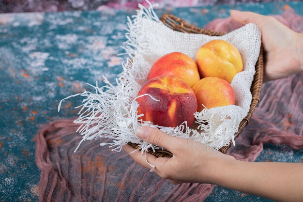 Yellow redish peaches on piece of white burlap.