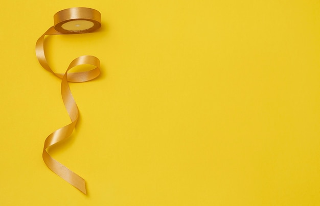 Free photo yellow ribbon on yellowish background