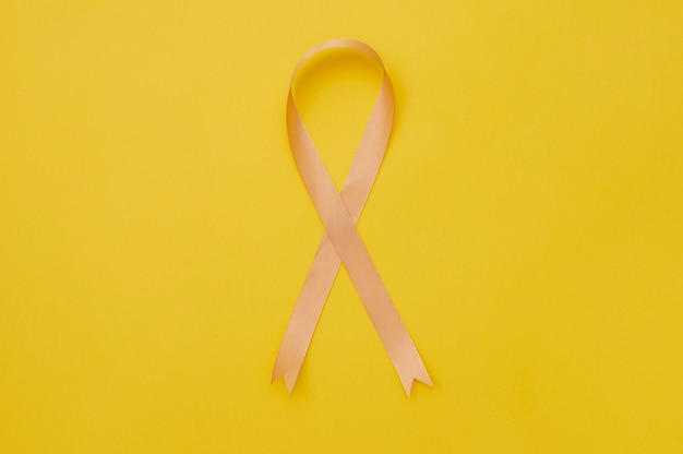 Free photo yellow ribbon on yellowish background