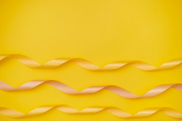 Free photo yellow ribbon on yellowish background