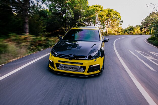 Yellow sport car with black autotuning. High speed drive.